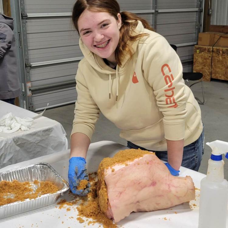 4-H member seasoning her country ham